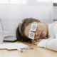 tired-businesswoman-covering-her-eyes-with-drawn-eyes-paper