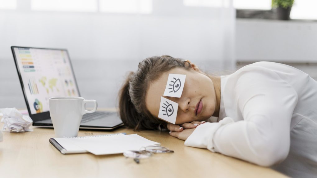 tired-businesswoman-covering-her-eyes-with-drawn-eyes-paper tired-businesswoman-covering-her-eyes-with-drawn-eyes-paper