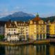 colorful-buildings-near-river-surrounded-by-mountains-lucerne-switzerland