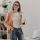 satisfied-female-entrepreneur-posing-with-laptop-hand-against-her-minimalistic-office