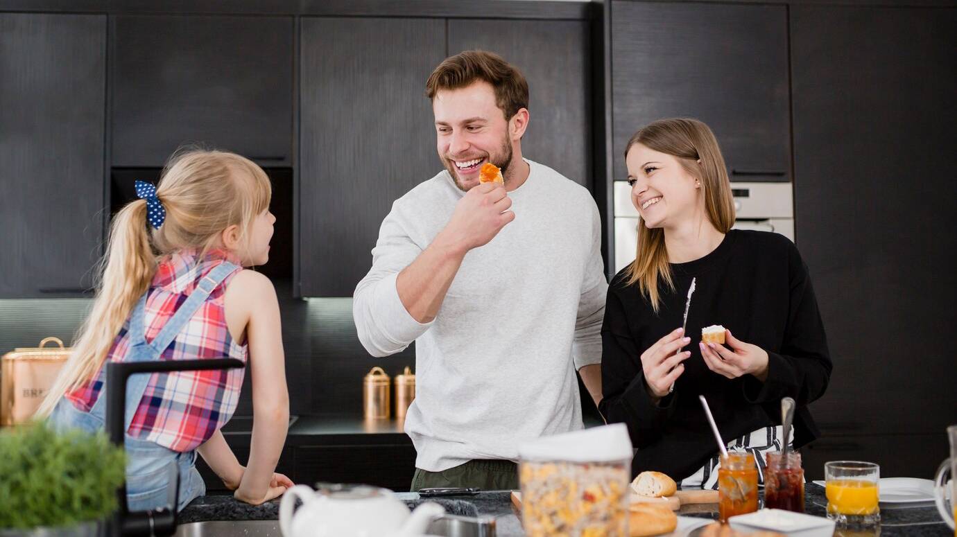 parents-cooking-near-daughter_23-2147800377
