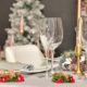 select-focus-of-a-table-with-glasses-a-pine-cone-wreath-and-other-christmas-decoratiion_181624-23484