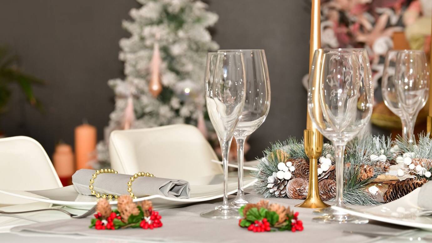 select-focus-of-a-table-with-glasses-a-pine-cone-wreath-and-other-christmas-decoratiion_181624-23484