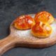 bottom-view-tasty-dinner-rolls-wood-board-black-wall_140725-144458