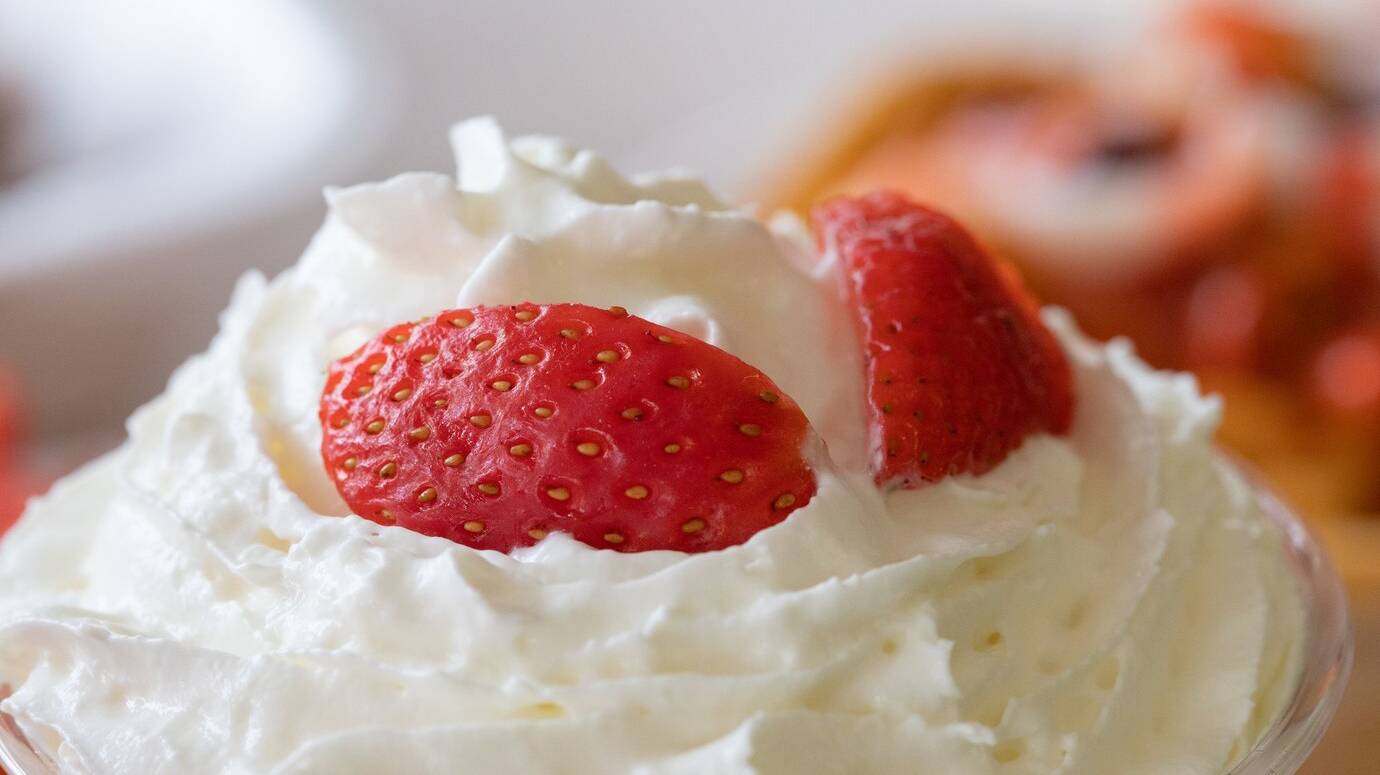 closeup-selective-focus-shot-of-whipped-cream-with-fresh-strawberries_181624-41935