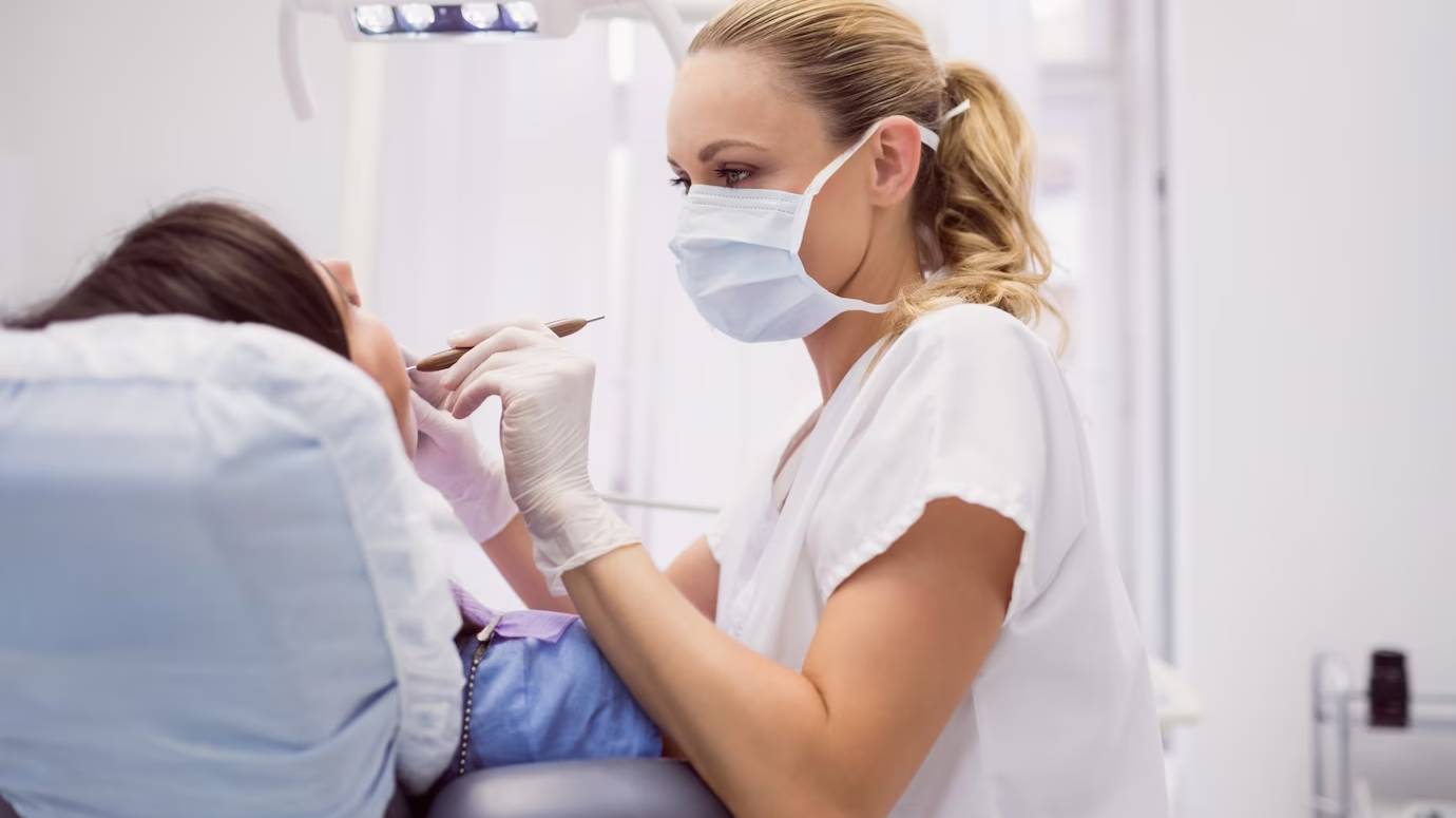 dentist-examining-female-patient_107420-65395