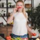 young-woman-standing-kitchen-smelling-red-chili_23-2147917760