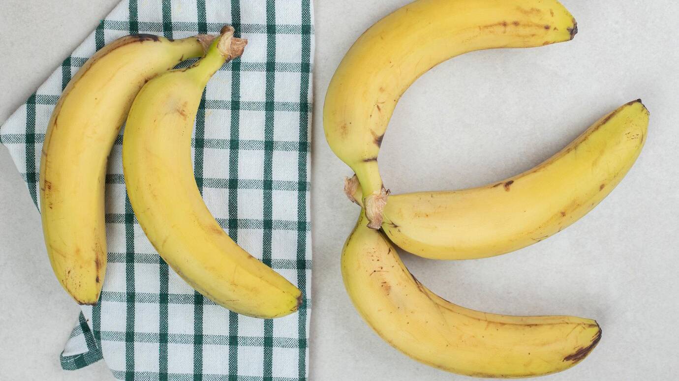 bunch-yellow-bananas-striped-tablecloth_114579-57737