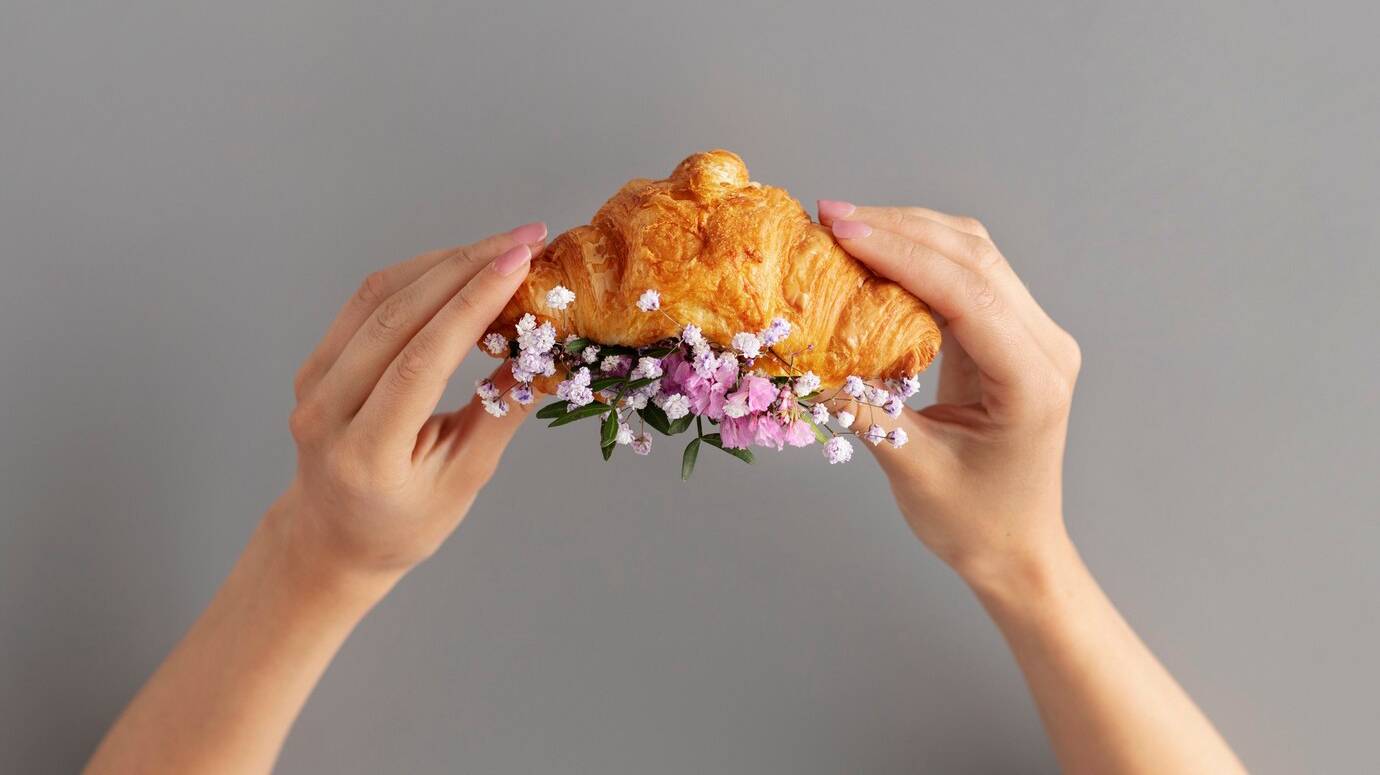 side-view-hands-holding-croissant_23-2149660916