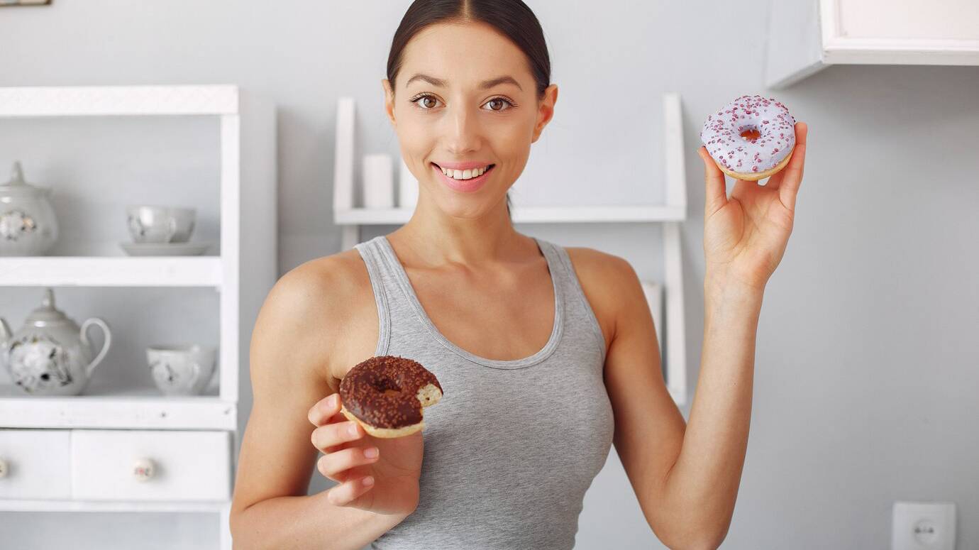 beautiful-woman-standing-kitchen-with-donut_1157-28020