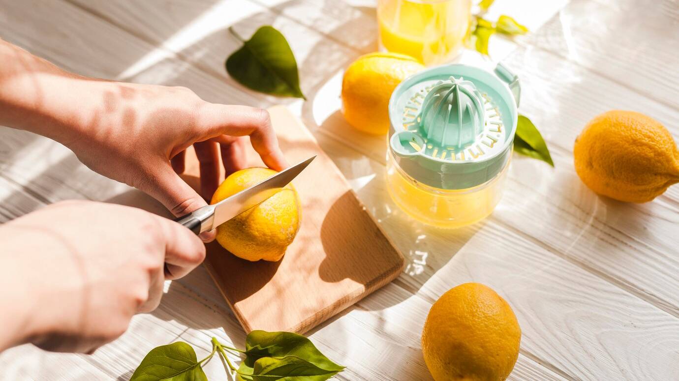 high-angle-hands-cutting-lemon_23-2148545906