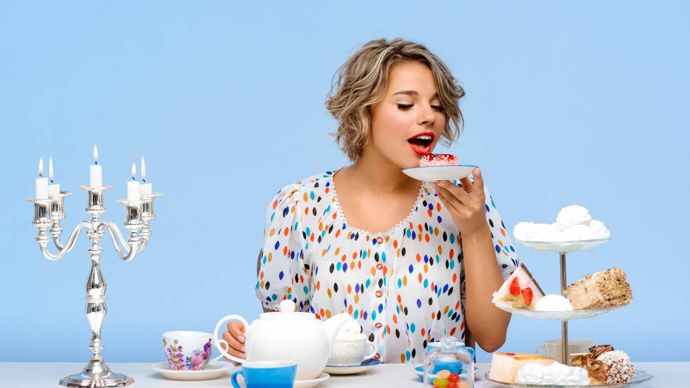 portrait-young-beautiful-woman-with-sweets-blue-wall_176420-3176