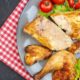 top-half-view-baked-chicken-fresh-tomatoes-lemon-slices-plate-napkin-black-table_140725-148762