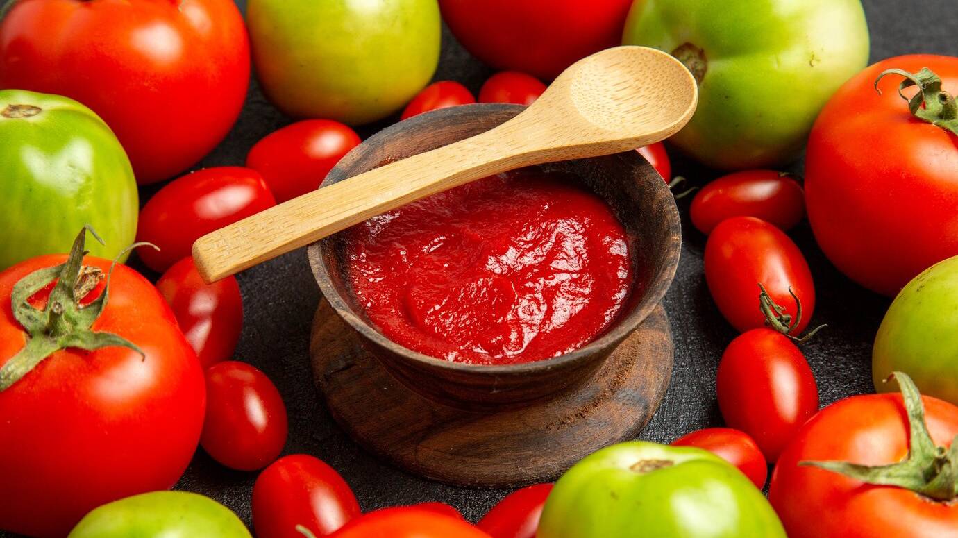 bottom-close-view-cherry-red-green-tomatoes-around-bowl-with-ketchup-wooden-spoon-dark-background_140725-91448