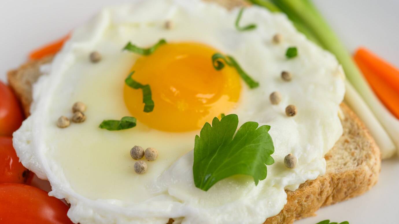 fried-egg-laying-toast-topped-with-pepper-seeds-with-carrots-spring-onions_1150-20992