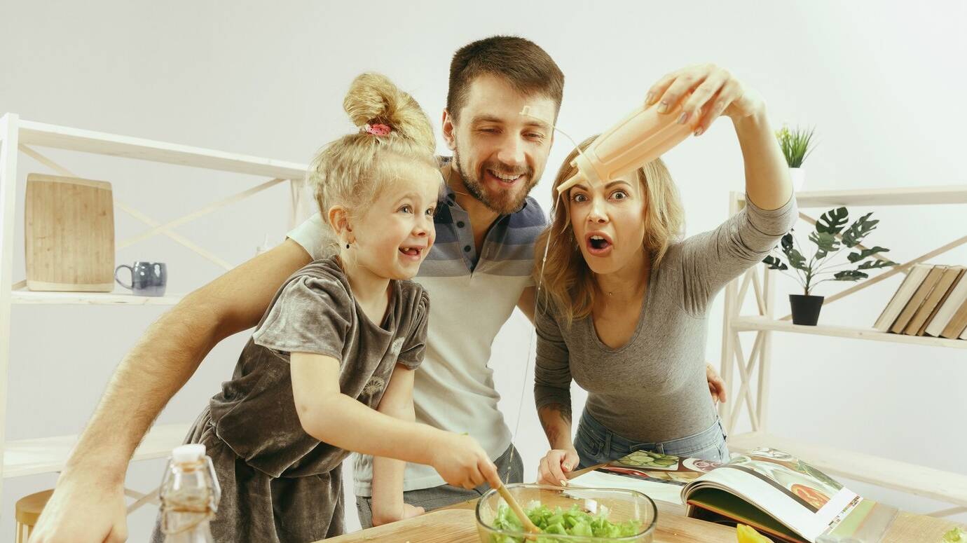 cute-little-girl-her-beautiful-parents-are-cutting-vegetables-smiling-while-making-salad-kitchen-home-family-lifestyle-concept_155003-18550