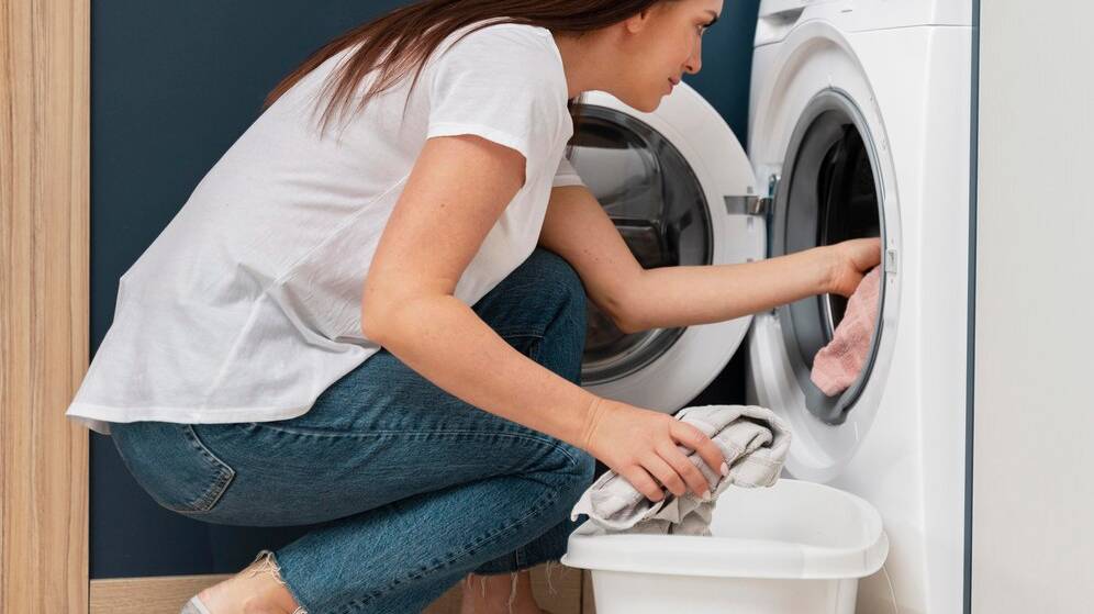 woman-putting-dirty-clothes-washing-machine_23-2149117030