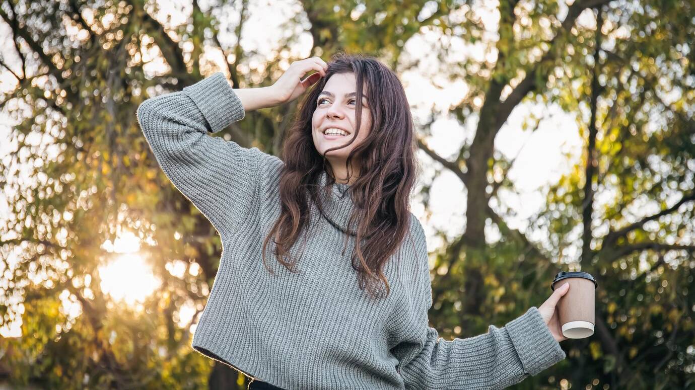 young-woman-sweater-with-cup-coffee-nature_169016-25135