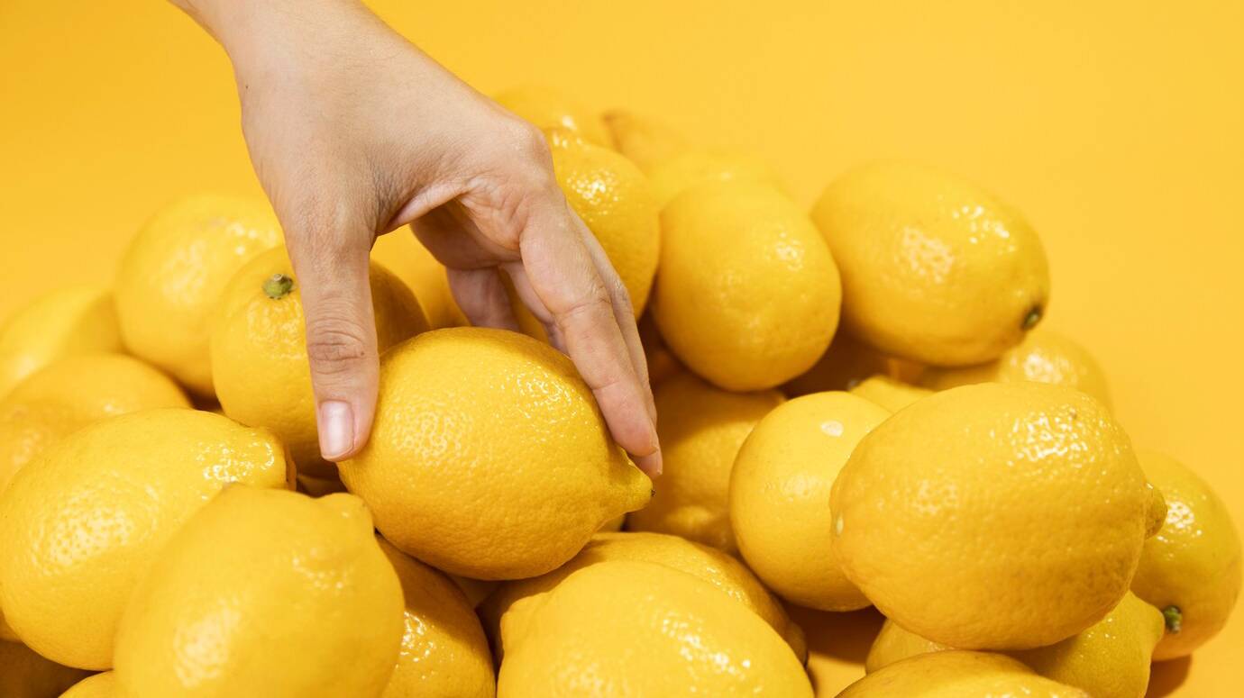 close-up-hand-touching-lemons_23-2148317839