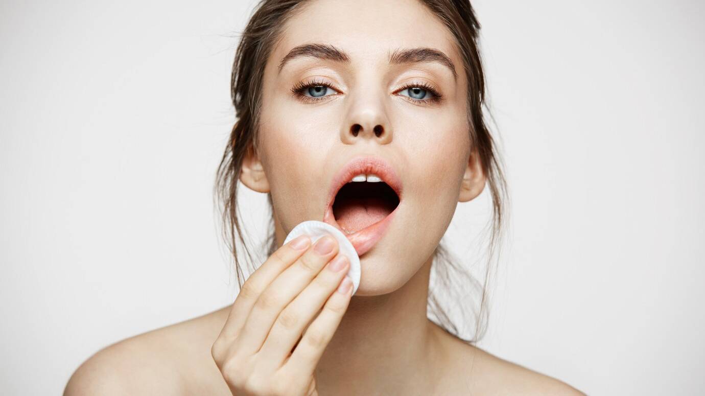 cute-beautiful-natural-brunette-girl-cleaning-face-with-cotton-sponge-smiling-looking-camera-white-background-cosmetology-spa_176420-14042