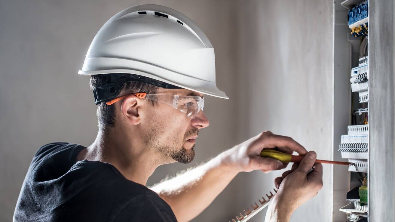 electrical-technician-working-switchboard-with-fuses-installation-connection-electrical-equipment_169016-5516