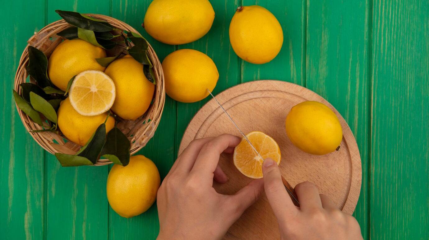 top-view-female-hands-cutting-lemon-wooden-kitchen-board-with-knife-with-lemons-bucket-green-wooden-wall_141793-76020 top-view-female-hands-cutting-lemon-wooden-kitchen-board-with-knife-with-lemons-bucket-green-wooden-wall_141793-76020