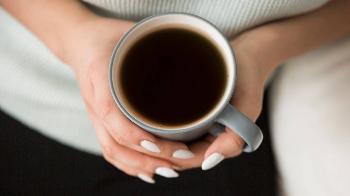 top-view-woman-holding-coffee_23-2147776748