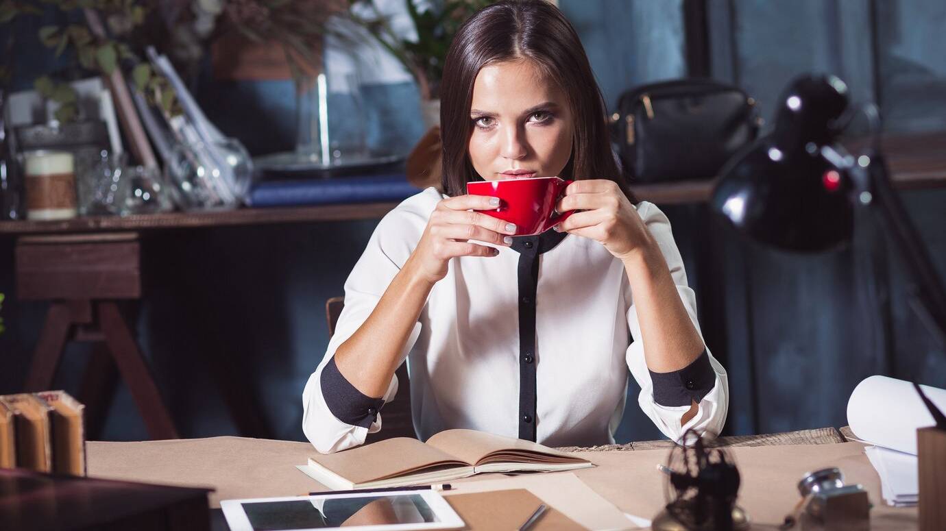 young-beautiful-woman-working-with-cup-coffee-notebook-loft-office_155003-37390
