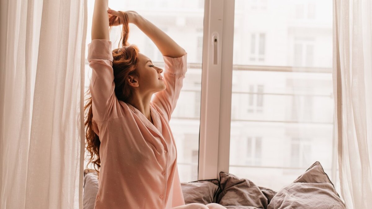 cute-female-model-pink-pajama-enjoying-morning-pleasant-ginger-woman-sitting-bed_197531-14196