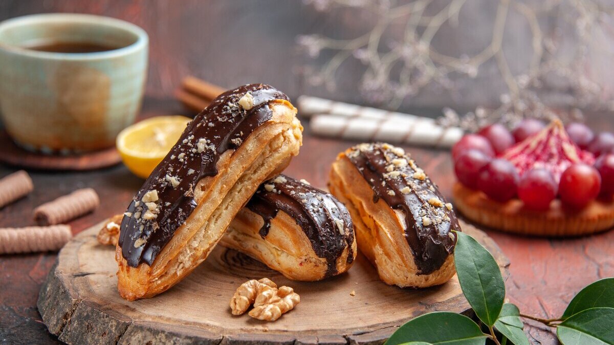 front-view-cup-tea-with-delicious-choco-eclairs-dark-background_140725-91632 front-view-cup-tea-with-delicious-choco-eclairs-dark-background_140725-91632
