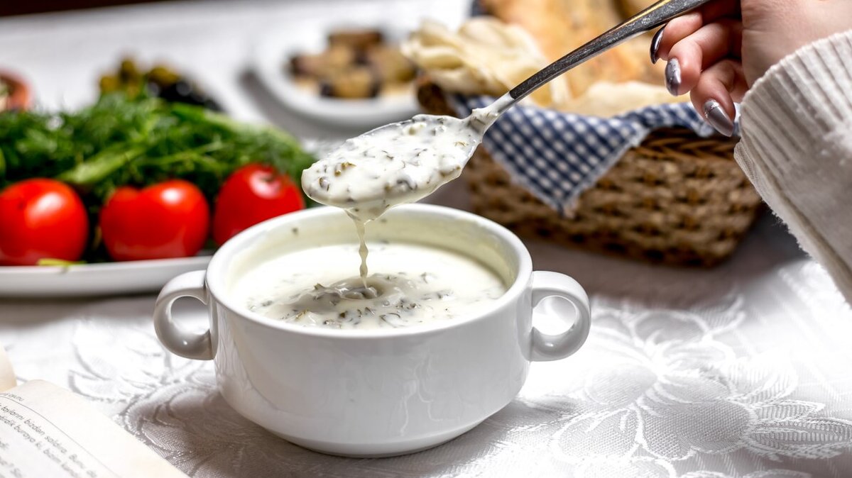 side-view-woman-eating-traditional-azerbaijani-dish-dovga-yogurt-soup-with-vegetables-herbs_141793-5183