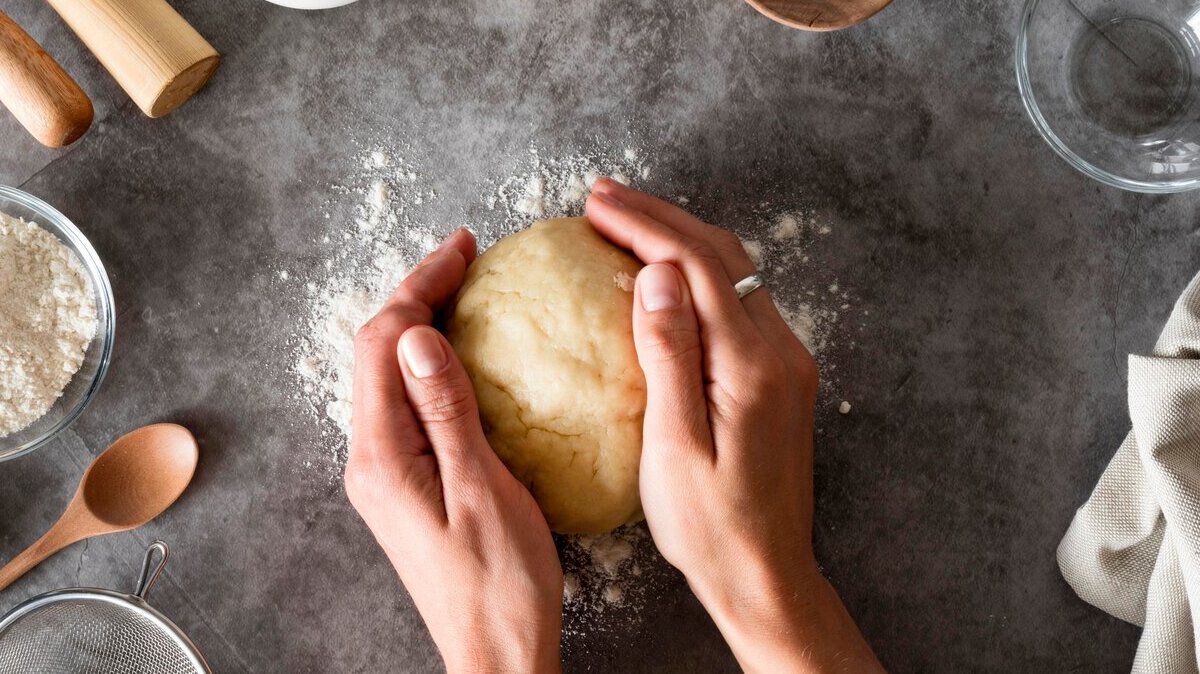 top-view-hands-holding-dough-counter_23-2148695566