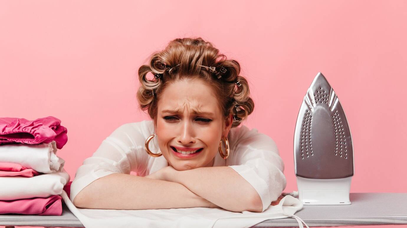woman-with-hair-curlers-leans-ironing-board-cries_197531-18341