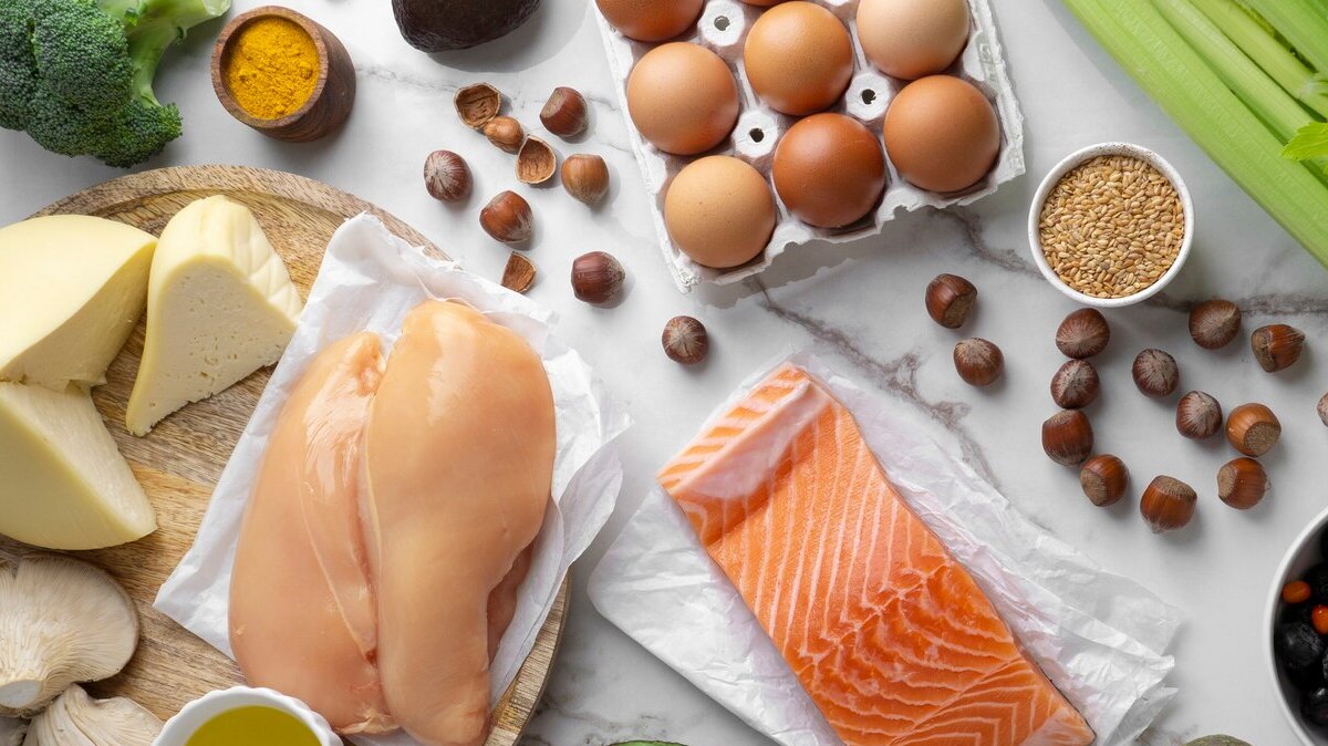 полезные продукты курица, рыба, сыр, яйца и орехи лежат на столе