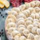 сырые пельмени на блюде рядом с овощами