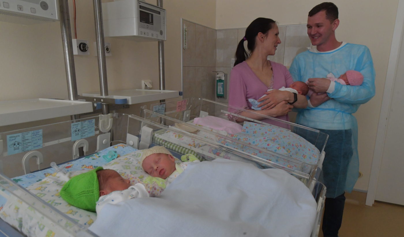 Родители держат на руках новорожденных